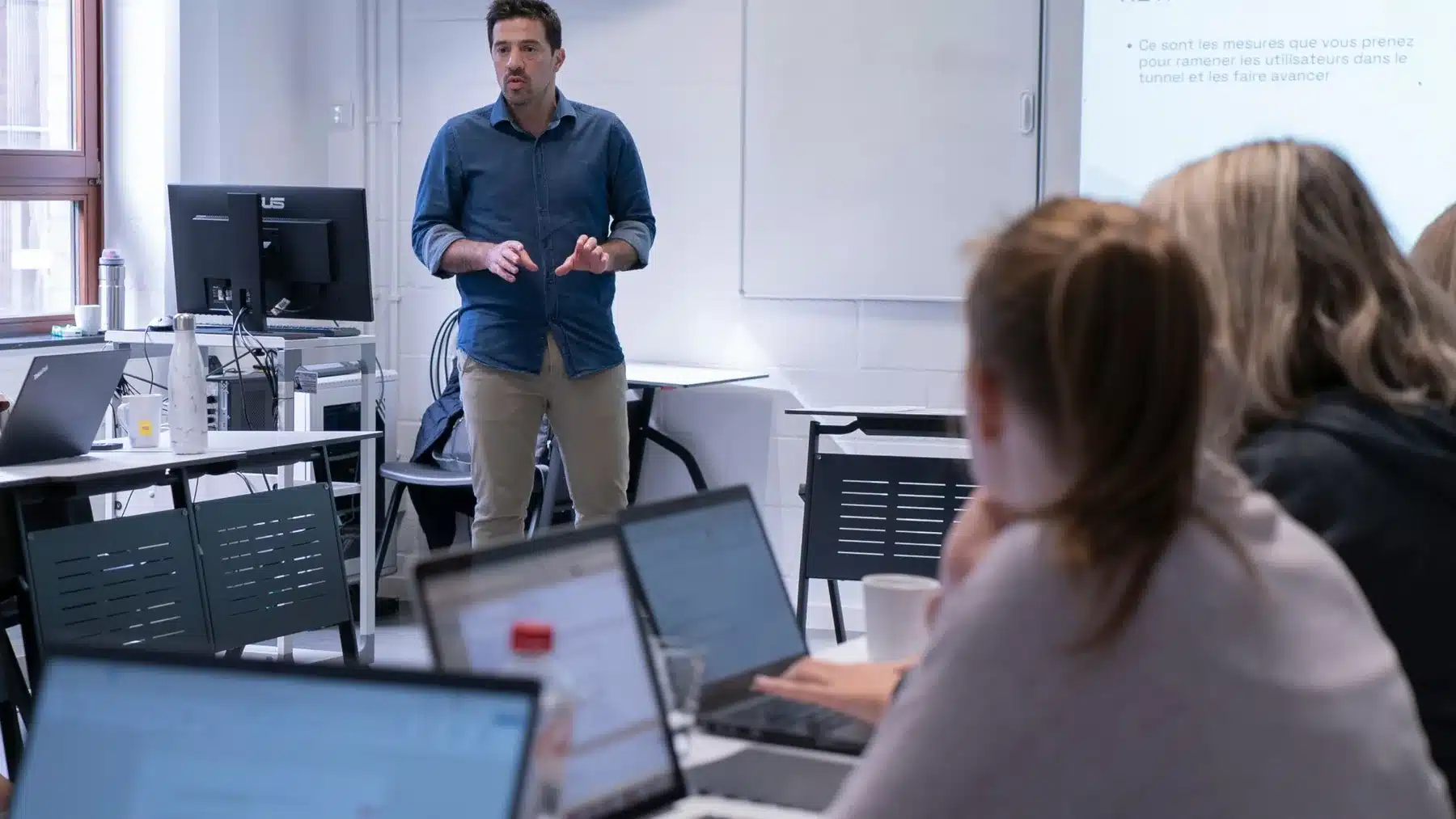 Massimo Melone explique une stratégie digitale devant un groupe, ordinateurs ouverts
